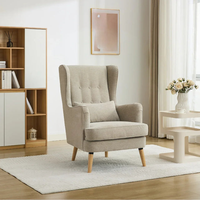 Beige wing chair with pillow on white rug in modern living room setting