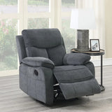 Grey fabric recliner armchair with extended footrest beside round side table and lamp
