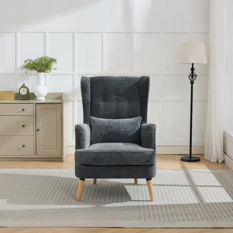 Dark grey wing chair with cushion and wooden legs on light rug in bright living room