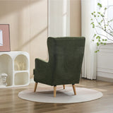 Moss green wing chair with pillow on wooden legs, shown from back in modern living room