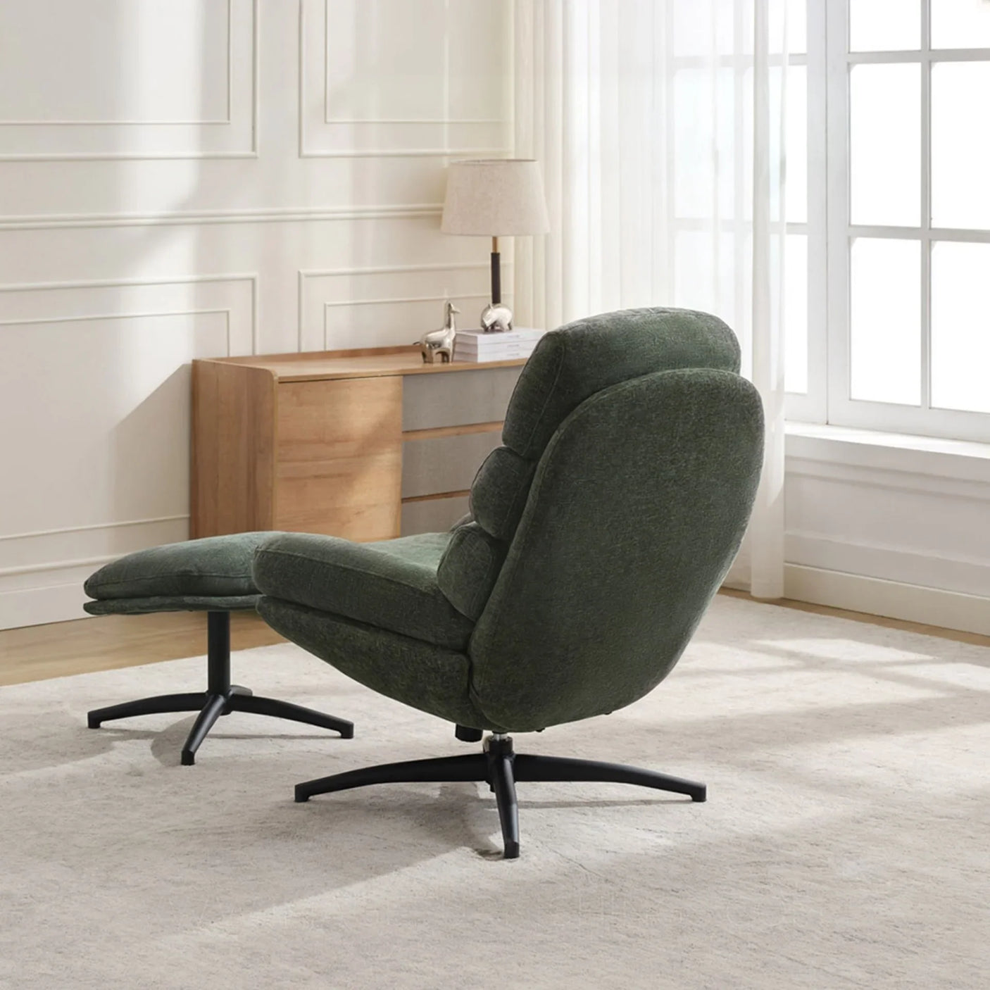 Green leisure chair with matching footstool, metal base, in bright modern living room