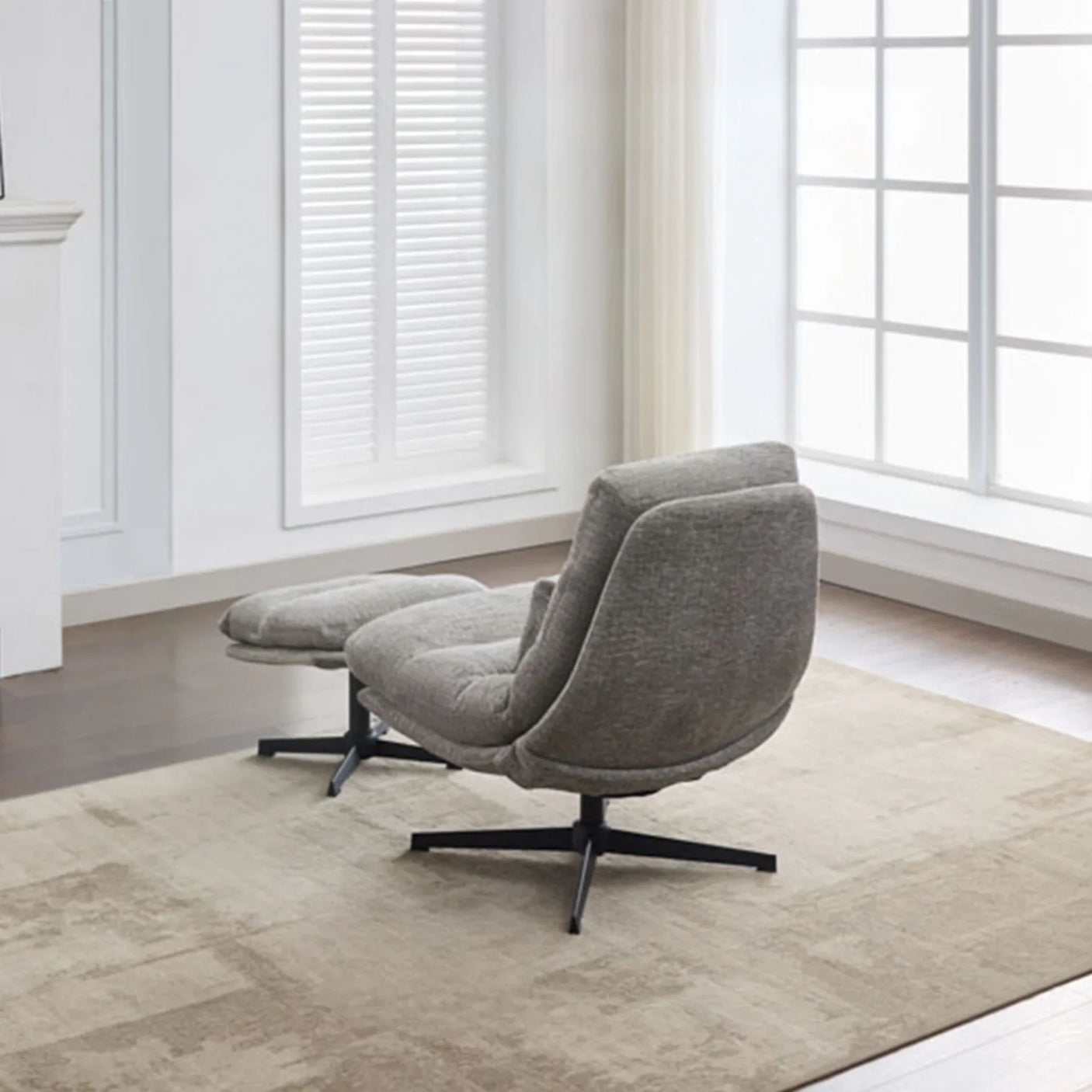 Grey leisure chair with footstool on beige rug in bright living room