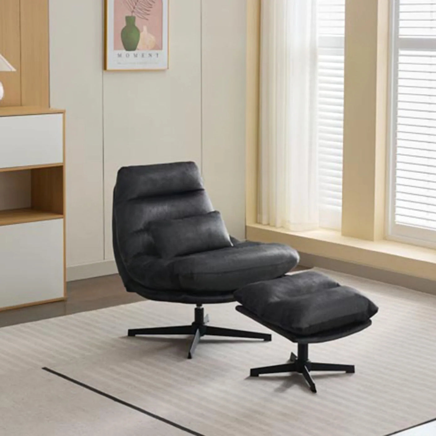 Dark grey leisure chair with matching footstool on modern rug near large windows