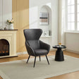 Graphite accent chair with high back and black legs in modern living room beside round side table