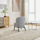 Ash grey accent chair with rounded backrest and black legs in modern living room setting
