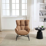 Rust accent chair with cushioned back and black legs beside modern round black side table