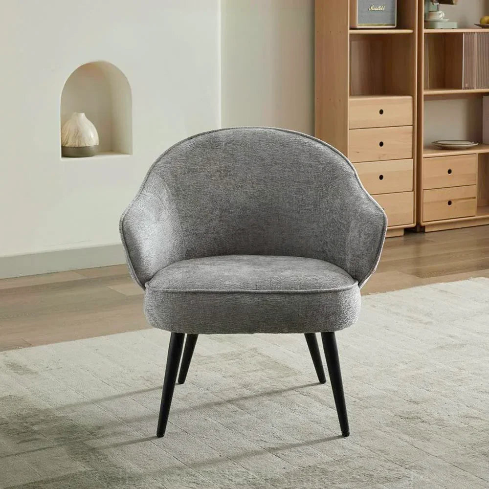 Light grey accent chair with fabric upholstery and black legs on a modern rug