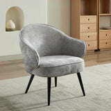 Light grey accent chair with curved backrest and black legs on a textured rug