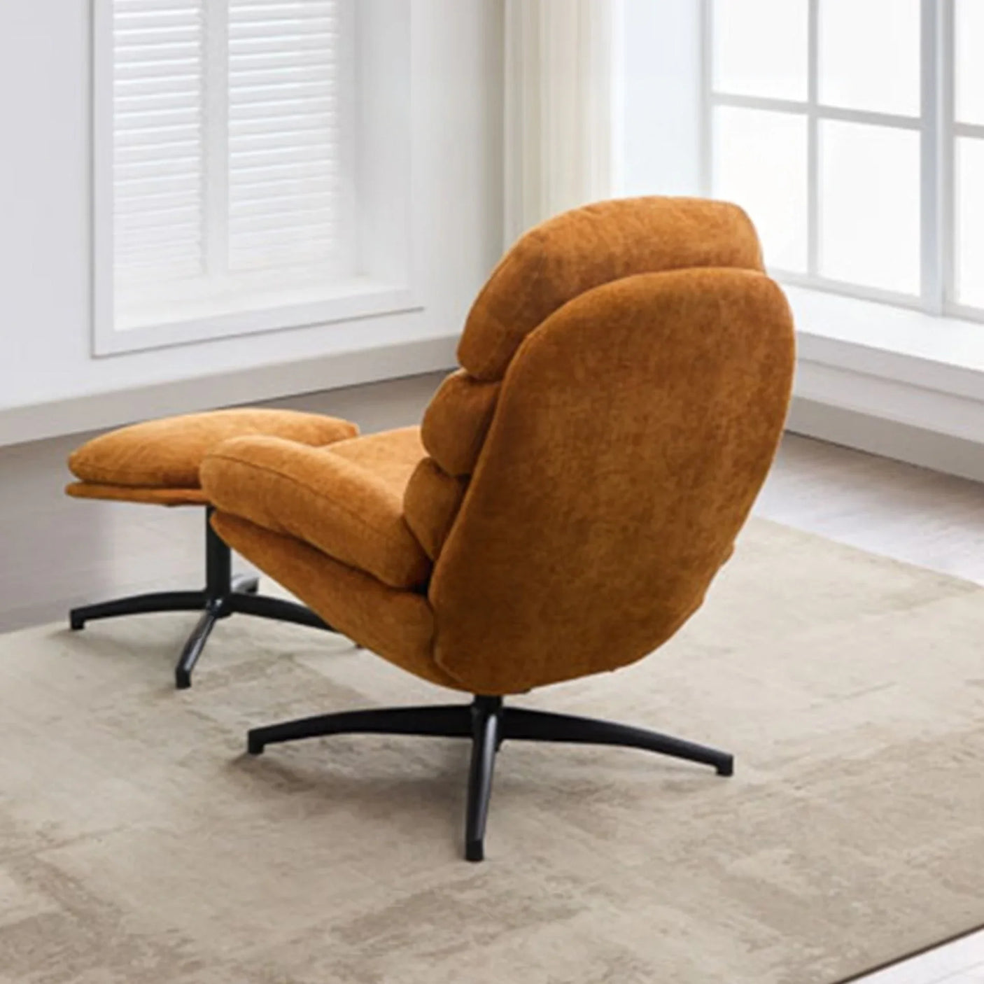 Gold leisure chair with footstool on beige rug by window, black metal legs