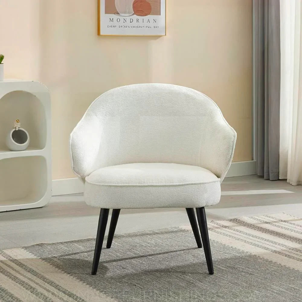 Cream accent chair with curved back and black legs on patterned rug in modern room