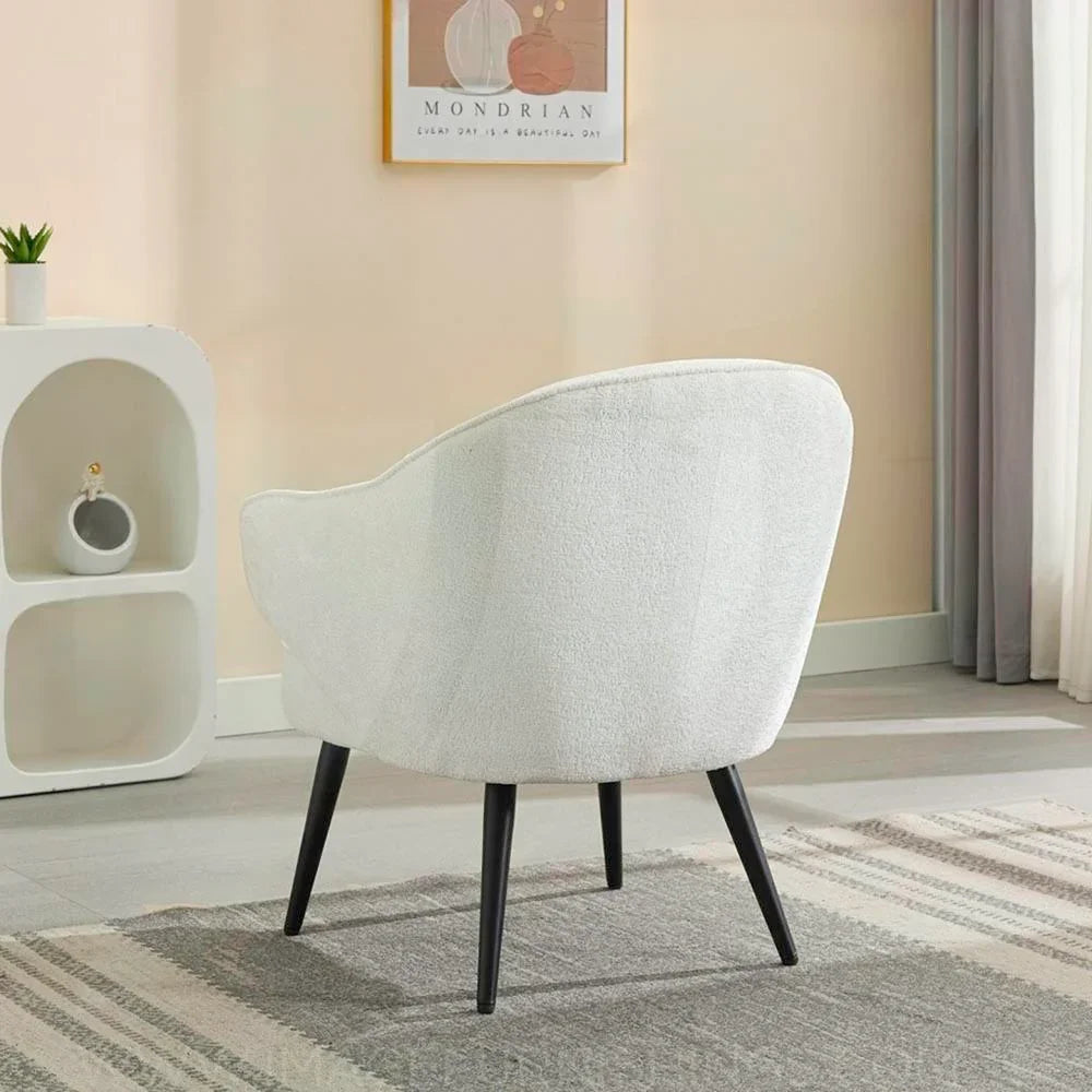 Cream accent chair with curved back and black legs on grey patterned rug