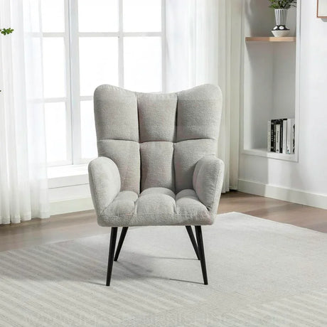 Light grey accent chair with wingback design and black legs in a modern living room