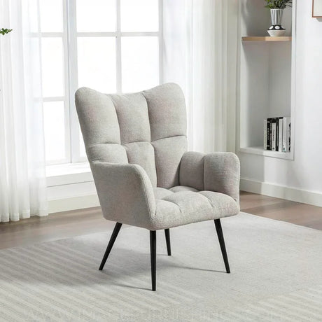 Light grey accent chair with tufted upholstery and black angled legs in modern living room