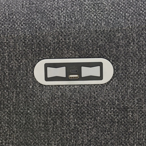 Close-up of USB charging ports set in dark grey fabric upholstery