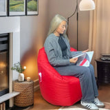 Red bean bag chair in living room with woman reading a magazine