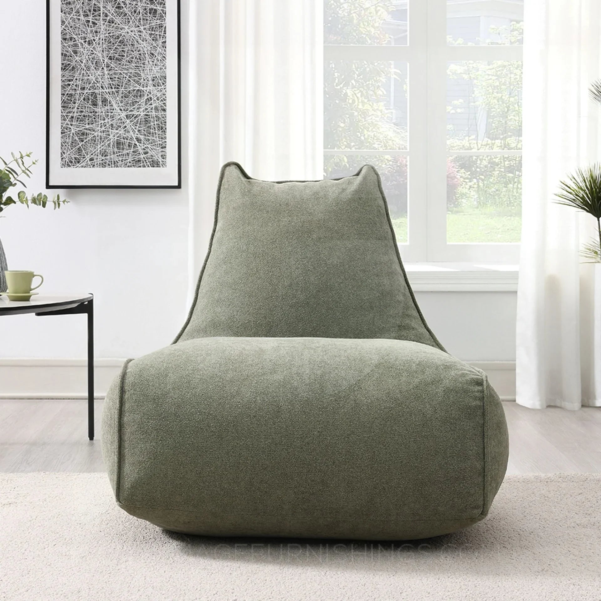 Pearl lounger bean bag in moss green fabric placed in a bright modern living room