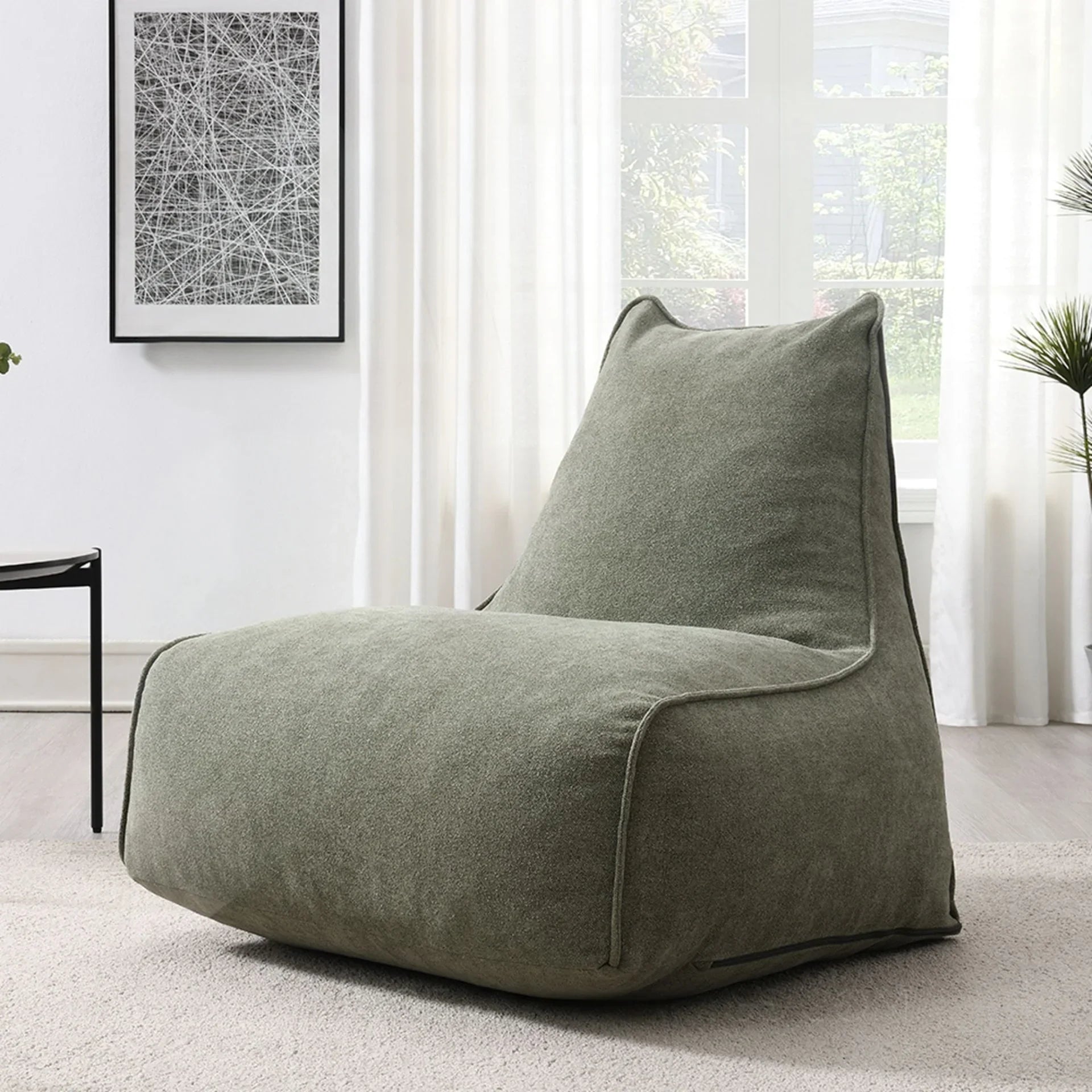 Moss green pearl lounger bean bag chair in a modern living room with light decor