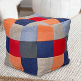 Patchwork fabric footstool with orange, blue, red, and beige squares on living room rug
