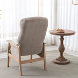 Oatmeal fabric armchair with wooden frame beside round wooden side table in bright room