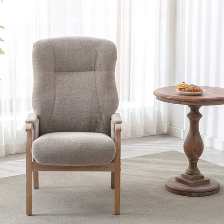 Oatmeal armchair with wooden legs beside round wooden side table in bright living room
