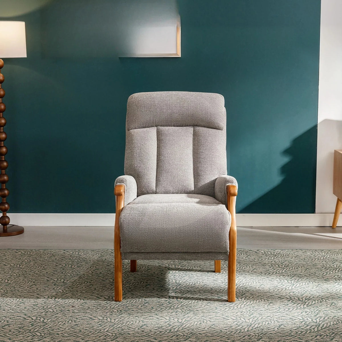 Silver fireside chair with wooden arms and legs on patterned rug in modern living room
