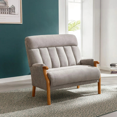 Silver fireside loveseat with wooden arms and legs on patterned rug in bright room