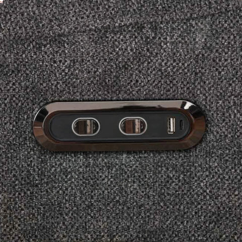 Close-up of power and USB control panel on dark grey swivel glide chair fabric