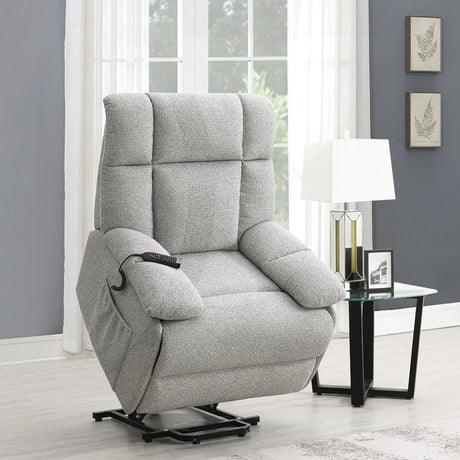 Grey lift and rise massage chair with remote in modern living room beside glass side table