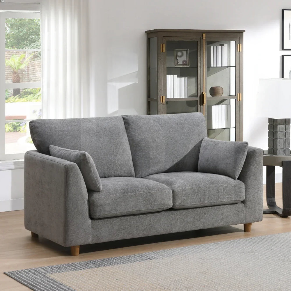 Modern grey fabric 2 seater loveseat with cushions in a bright living room