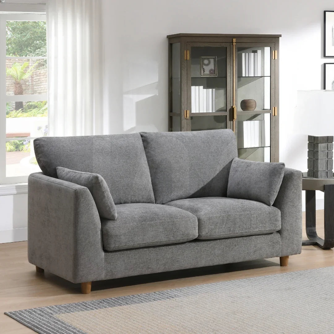 Modern grey fabric 2 seater loveseat with cushions in a bright living room