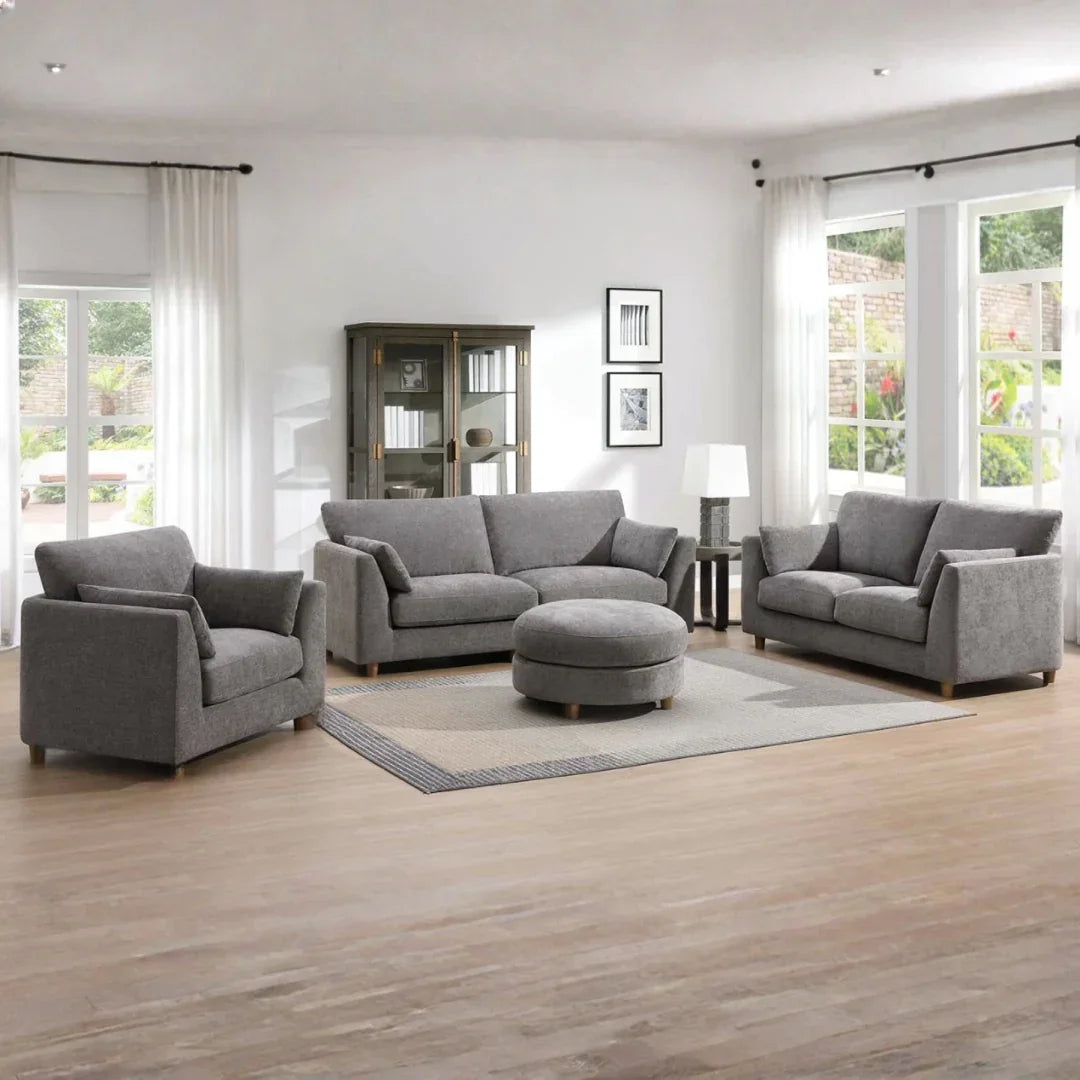 Grey modular 2.5 seater sofa in living room with matching armchair and ottoman on wood floor