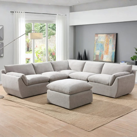 Light grey sectional sofa with matching ottoman in modern living room on beige rug