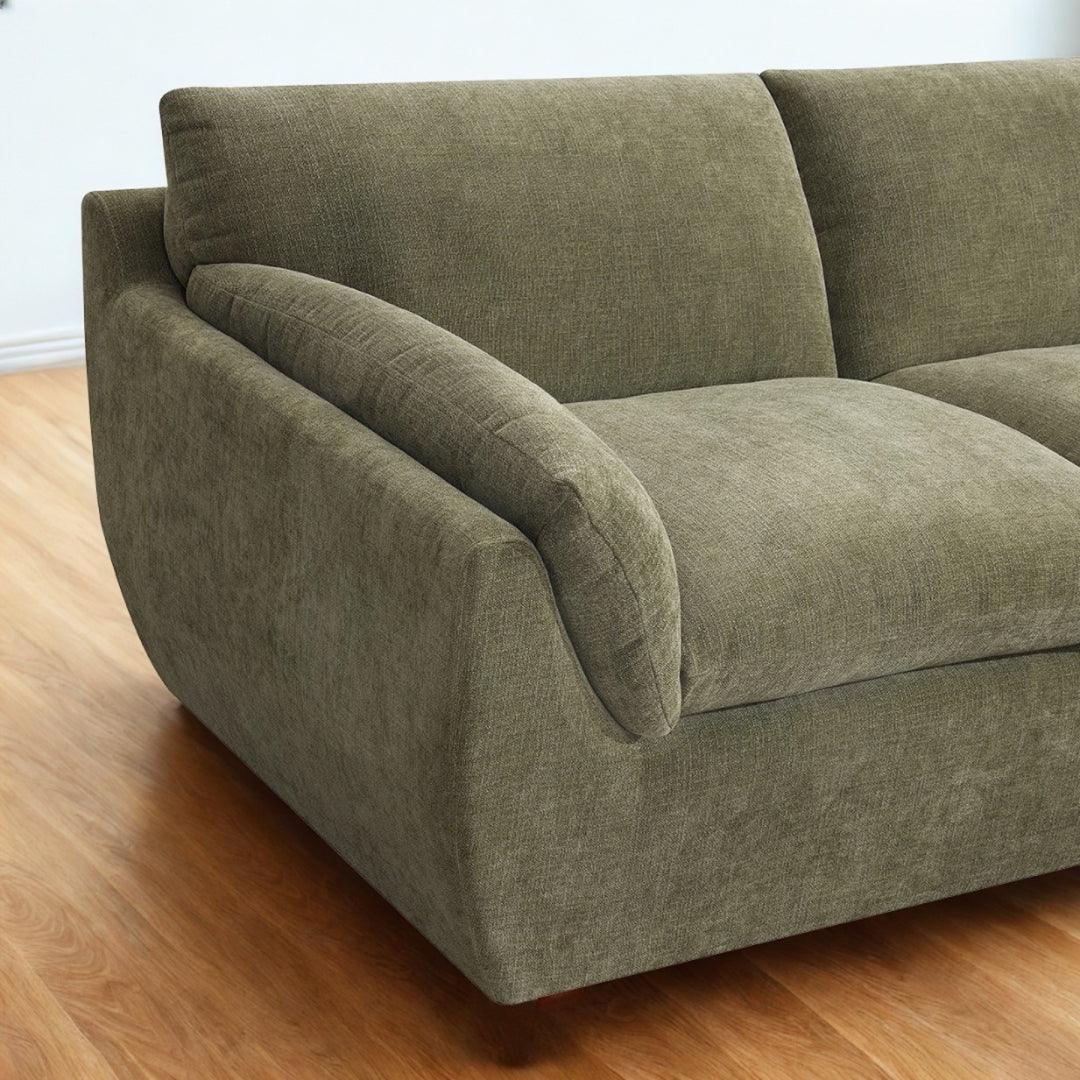 Forest green sectional sofa with soft fabric upholstery and wide padded armrest close-up