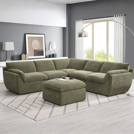 Forest green sectional sofa with ottoman on modern rug in bright living room