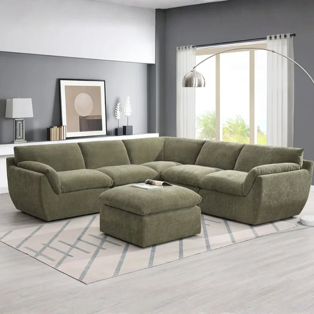 Forest green sectional sofa with ottoman on modern rug in bright living room