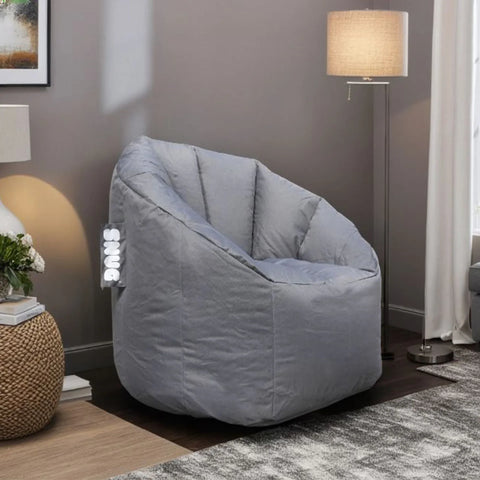 Grey fabric bean bag chair in living room with lamp and textured side table