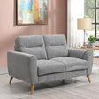 Grey fabric sofa with wooden legs in modern living room setting near window and side table