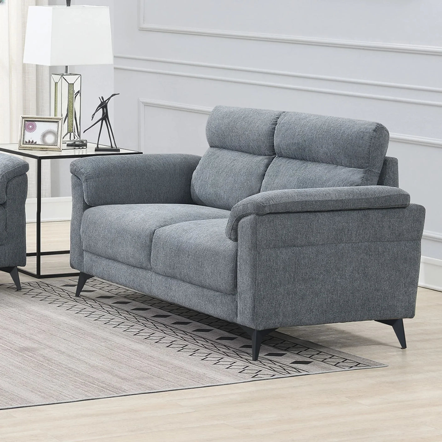 Grey fabric sofa with padded backrest and armrests in a modern living room setting
