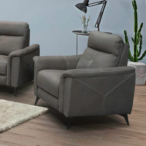 Grey one-seater sofa chair with angled arms and white stitching in a modern living room