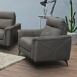 Grey one-seater sofa chair with angled arms and white stitching in a modern living room