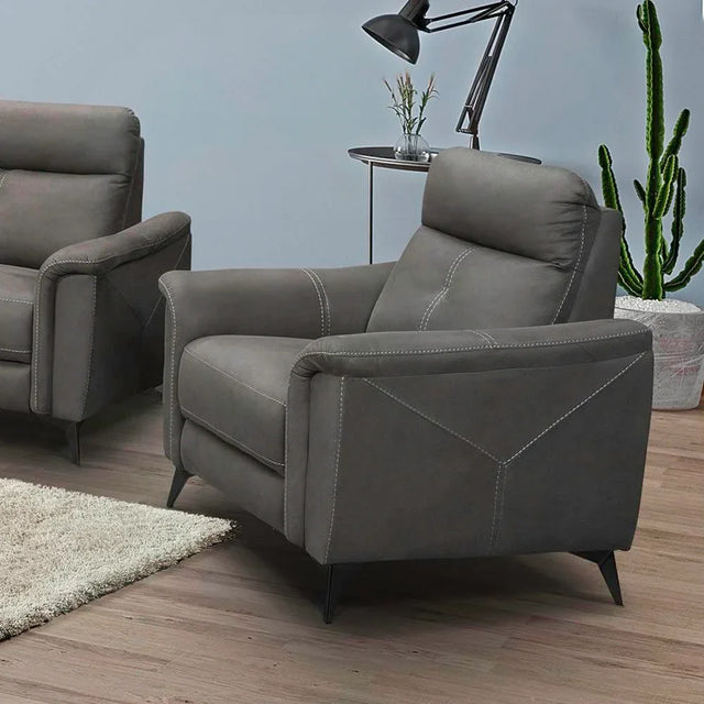 Grey one-seater sofa chair with angled arms and white stitching in a modern living room