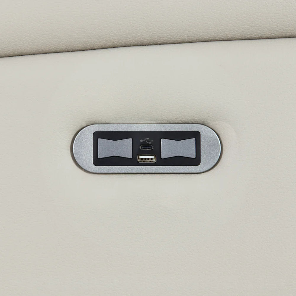 Closeup of sofa USB charging port on light grey leather upholstery