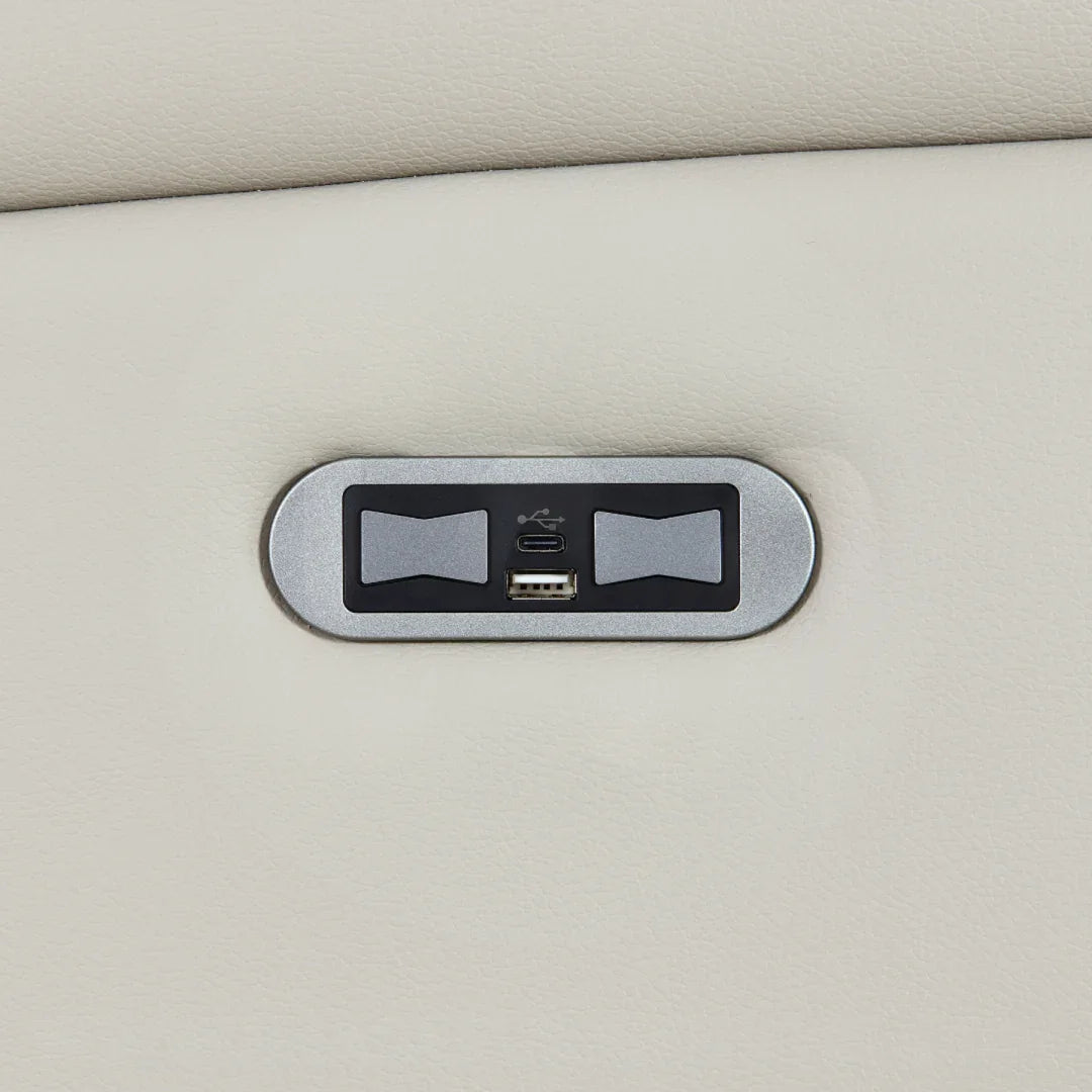Closeup of sofa USB charging port on light grey leather upholstery