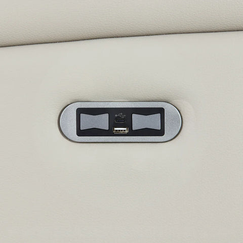Closeup of sofa USB charging port on light grey leather upholstery