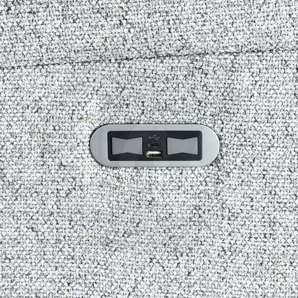 Close-up of USB charging port on silver fabric sofa