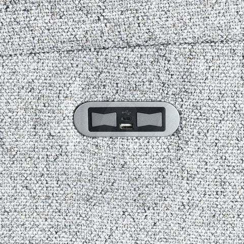 Close-up of USB charging port on silver fabric sofa