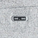 Close-up of USB charging port on silver fabric sofa