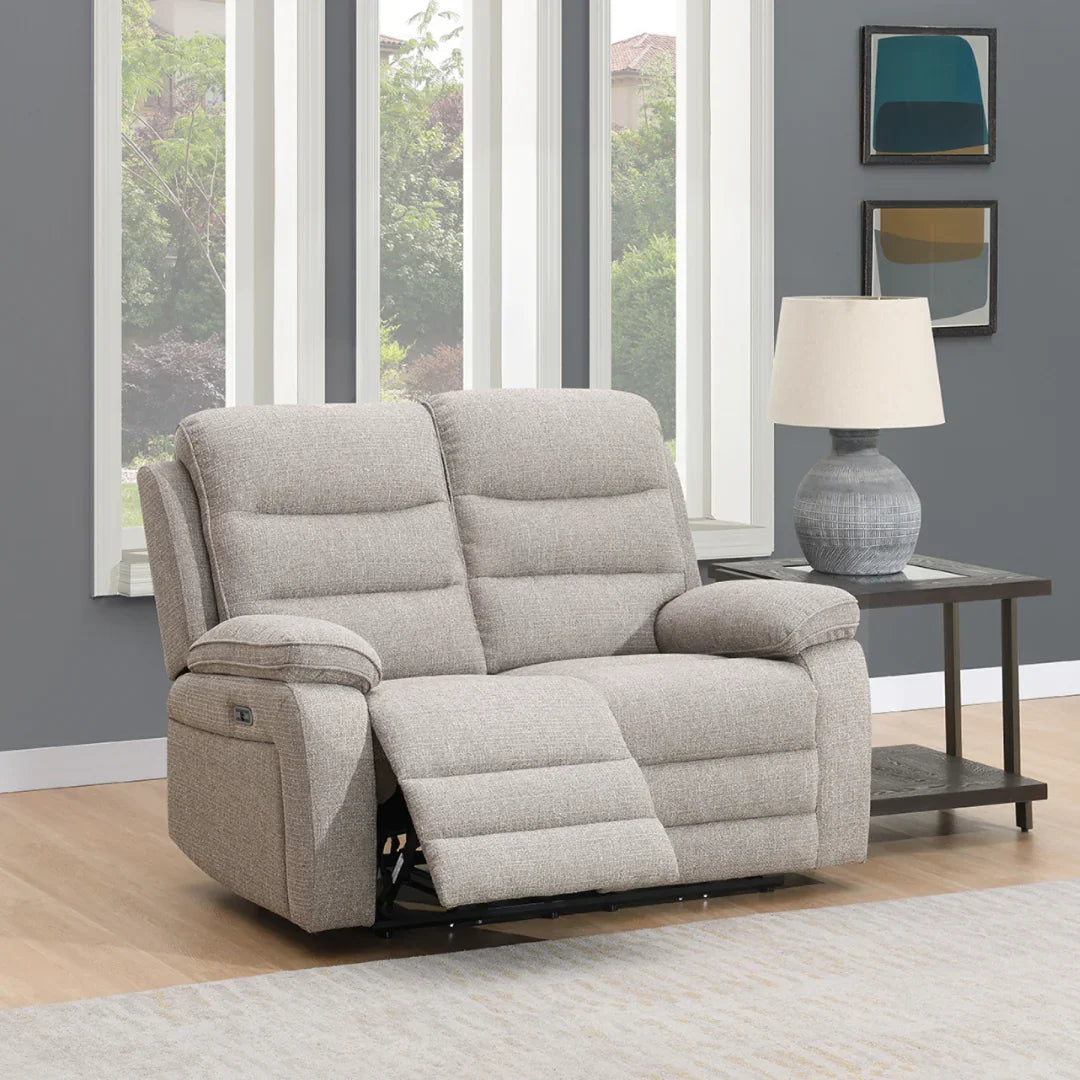 Beige fabric 2 seater reclining sofa with padded arms in living room beside lamp table