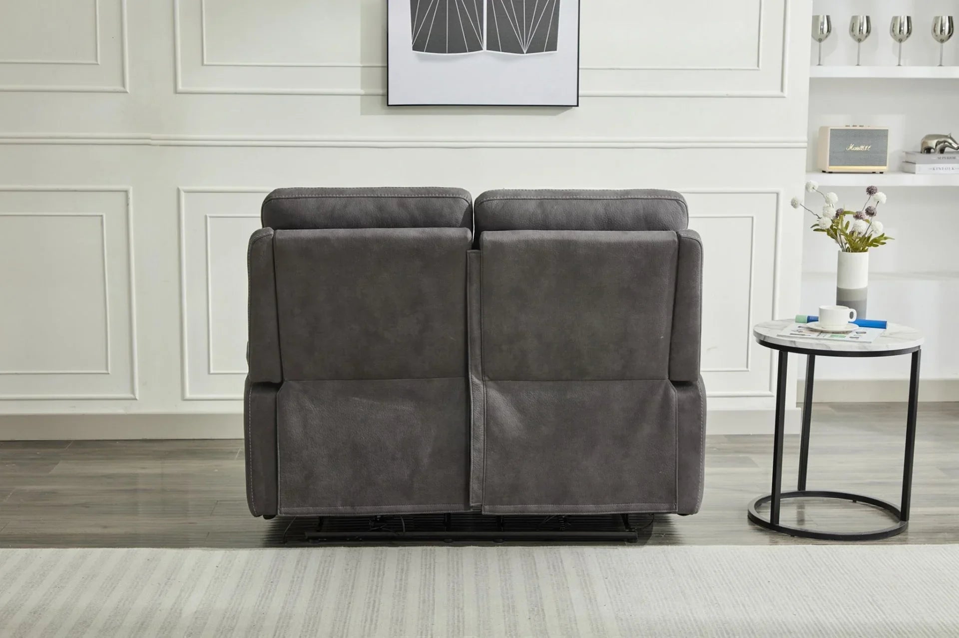Back view of grey two seater fabric sofa beside round marble side table in modern room