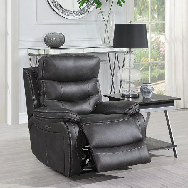 Grey leather recliner chair with padded seat and footrest beside modern lamp table
